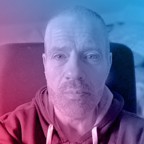 Portrait of Paul sporting trimmed haircut and beard.